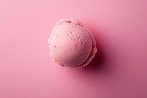 A top-down view of a pink ice cream scoop on a matching pink background. photo