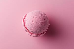 A top-down view of a pink ice cream scoop on a matching pink background. photo