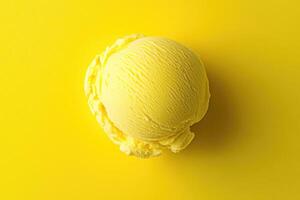 A top-down view of a yellow ice cream scoop on a matching yellow background. photo