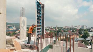 a construtor trabalho em a construção local. instalação do metal estruturas para o preenchimento com uma monólito. construtor sem capacete e reflexivo colete. video