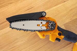 opened view of a small light chain saw to trim broken branches of a tree photo