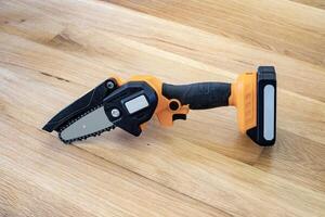 small accumulator chainsaw to trim broken branches of a tree photo