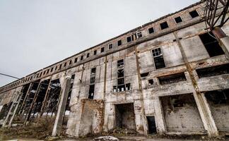 Abandoned building. Old factory ruin and broken windows. photo
