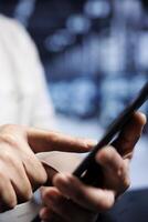 System administrator using tablet in high tech workplace, installing dedicated VPN servers able to provide encrypted sensitive data, online anonymity and fast speed bandwidth to customers, close up photo