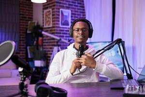 Lifestyle vlogger recording podcast episode with professional camera and sound equipment in studio. Portrait of content creator talking to audience and filming streaming service online show photo