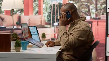 Entrepreneur reviewing statistics data on a laptop remotely from his house, makes a briefing report. Business owner studying sales numbers and the profit to increase organizational funds. Camera A. photo