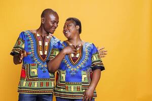 Smiling man and woman couple looking at each other with affection, showing love and happiness while standing together. Cheerful black wife and husband family posing in studio photo