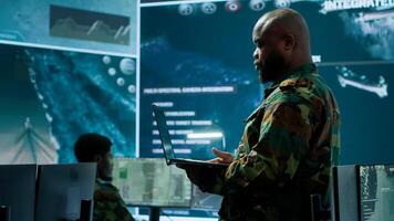 Military team manages cybersecurity operations in a high tech control center base of operations, managing data protection and surveillance systems, safeguarding national security. Camera A. photo