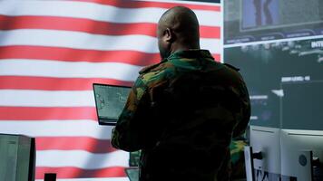 Team of military experts operates high tech computers and tablet to analyze surveillance data and manage national security operations. Working with CCTV radar satellite imagery. Camera A. photo