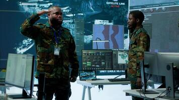 Military personnel operate advanced systems in a command center, focusing on surveillance and data analysis to protect national security. Soldiers trained to manage information warfare. Camera A. photo