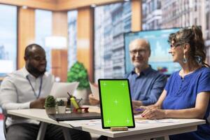 Senior man and woman meeting with advisor in modern office, isolated chroma key screen on laptop. Financial expert helping clients choose the suitable retirement plan for them. photo
