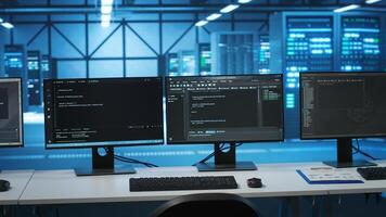Computers in empty high tech data center establishment monitoring hardware energy consumption. PC monitors on desk used for checking potential system failures in server room photo