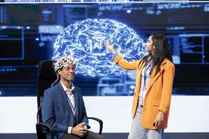 Professionals speaking at tech conference, explaining impact of neural implants and AI tech. Neuroscience researchers present risks and threats associated with EEG headsets usage photo
