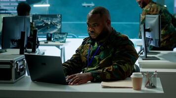 Intelligence agents in modern operations center managing surveillance activity and synchronizing security protocols. Army base staff interpret real time data to protect national interests. Camera A. photo