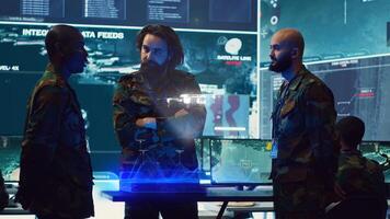 Operators in control room use augmented reality military technology to identify enemy threats. Counter intelligence agency agents using AR tech software to relay info to generals on war front line photo