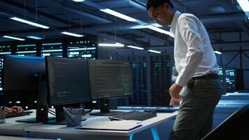 Data center computer scientist responsible for installation of networking equipment solving tasks. Indian man at work doing maintenance on server room infrastructure, camera B photo