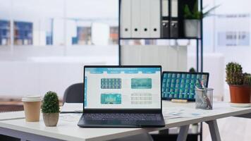 Financial analyst workspace featuring laptop and tablet displaying stock market data and statistics. Devices on desk in office next to paperwork with forex trading economic analytics figures photo