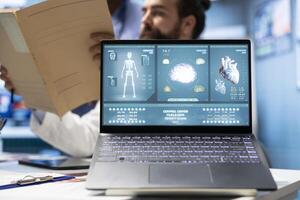 Specialists team analyzing electrocardiogram results and anatomy scans to develop effective treatment plan against a condition. Medical staff review analytics and hospital records. Close up. photo