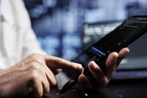 System administrator coding in data center using javascript language, close up. Competent manager updating software on server rigs on tablet terminal, ensuring optimal performance and security photo