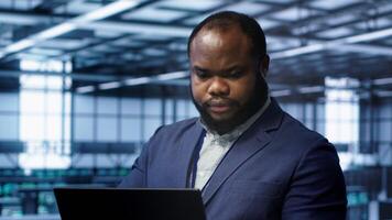 Software developer in data center runs diagnostic tests and error checking utilities on laptop to fix problems. IT expert looking for network issues affecting rigs performance using notebook, camera A photo