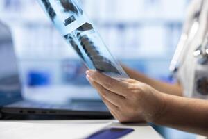 In a treatment center, physician reviewing radiography data on scan and putting diagnostic. Medical expert analyzing x rays and results, developing treatment plans and disease prevention. Close up. photo