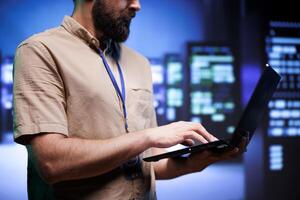 Proficient employee ensuring high tech server hub systems provide redundancy, automatic failover and rapid reconfiguration of clusters to minimize failure of individual machines photo