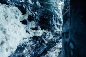 Ice caves inside vatnajokull glacier, global warming affecting icelandic nature and landscapes. Water dripping from ice blocks in crevasse icy structure, frozen rocks in iceberg. photo
