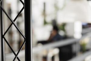 Blurred start up business office with employee working on background and metal rack close up. Company executive manager worker in modern coworking space workplace selective focus photo