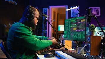 Skilled music producer composing new soundtracks on console and daw software, working with stereo gear in home studio. Young artist engineer uses pre amp knobs, signal processing. Camera B. photo