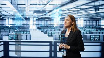 System administrator using augmented reality technology in data center, comparing parameters. Server farm manager looks at AR simulation, overseeing performance benchmarks photo