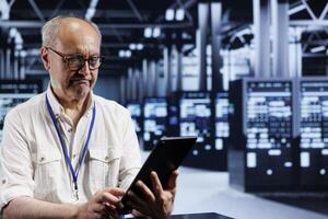 Adept worker in data center providing dedicated VPN servers able to deliver advanced privacy, encrypted sensitive data, online anonymity and secure internet connections to users photo