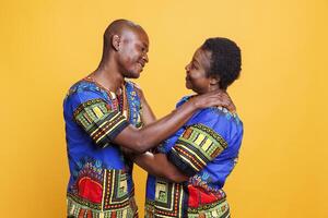 Smiling african american romantic couple looking at each other with love and hugging. Man and woman spouse standing together and embracing while showing affection and happiness photo