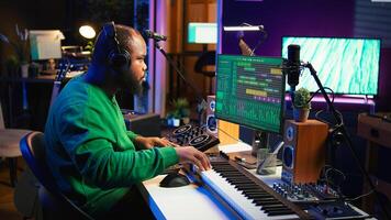 Talented musician mixing and mastering songs on a console, twisting pre amp knobs to add sound effects in post production. Producer composing tracks for album, working in home studio. Camera B. photo