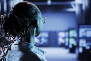 Certified technician in server room future proofing network from downtimes and unexpected system failures. Licensed expert ensuring reliable operations and increased data security photo