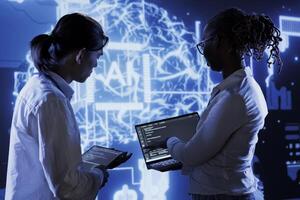 Trained programmers brainstorm ways to use AI cognitive computing to extract usable information from complex data. Adept employees implement artificial intelligence to process massive datasets photo