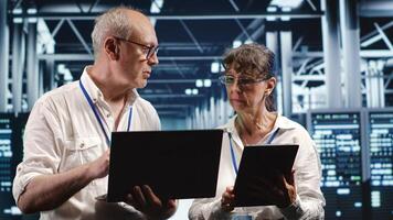 Professionals monitoring energy efficient data center equipment. Server components using renewable sources employed to minimize consumption and reduce overall establishment carbon footprint photo