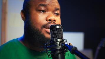 Skilled composer producing a new melody with lyrics and piano keys, recording audio files to edit them with mixing console. Young talented artist producer creating soundtracks. Camera B. photo