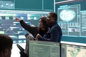 Governmental hackers analyzing cyber threats on big screens, managing important database hacking activity in high tech agency office. Work on cyber defense to protect national security. photo