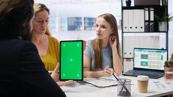 Broker holding green screen tablet, meeting with clients to provide stock exchange analysis. Financial advisor with chroma key device looking at market shares, helping family maximize income, camera A photo
