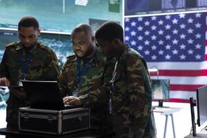 Military team operates high tech computers and a big screen in a command post, managing advanced surveillance systems, protecting national security and handling cybersecurity threats. photo