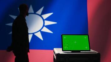 Taiwan army commander devising strategy to combat Chinese propaganda next to green screen tablet. Taiwanese freedom fighter walking in operation room in front of mockup device, camera B photo