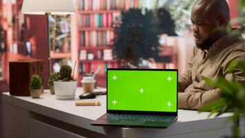 Young entrepreneur reviewing budget balance reports at his home desk, using mockup copy space display on a tablet. Businessman reviews monthly sales to obtain new investment funds. Camera A. photo