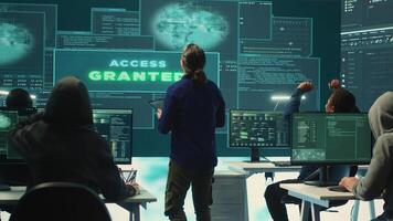 Group of professional hackers gaining access into government database to steal important information for hybrid warfare. Experts work on scams and phishing activity in high tech office. Camera A. photo