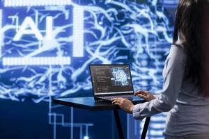 AI computer scientist using laptop for business data analysis in high tech workplace. Close up shot of woman working on notebook to automatize tasks using artificial intelligence photo