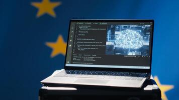 AI software on laptop used by European Union member states security services to prevent terrorism. Artificial intelligence tech used by Europe countries to defend, isolated over EU flag, camera A photo