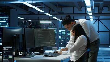 Admin in data center working with colleague to maintaining accurate documentation of equipment, generating reports. Server hub teamworking coworkers doing disaster recovery planning, camera A photo