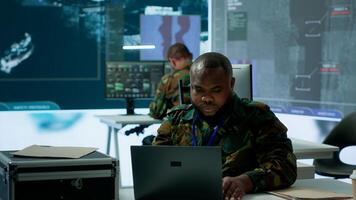 Military intelligence specialist uses high tech satellite systems and cctv radar to ensure national protocols, strategic missions for defense operation in command post control tower. Camera A. photo