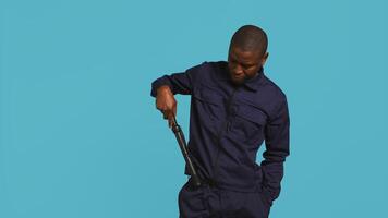 Portrait of security staff member tasked with evicting trespassers, intimidating them with baton. Patrolling agent maintains secure environment using truncheon weapon, studio background, camera B photo