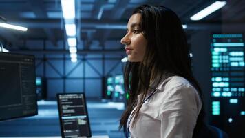 IT specialist in data center providing technical support to customers, troubleshooting issues. Server farm worker carrying out operational technical interventions requested by clients, camera B photo