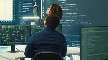 Governmental hackers analyzing data for cyber threat detection, looking at a big screen in high tech office. Highlight cyber intelligence, online security and prevention of digital threats. Camera A. photo